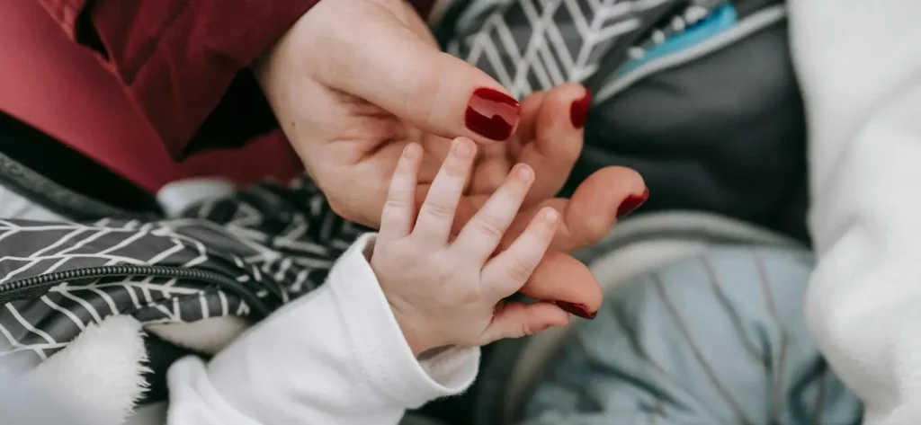 Bebé dando la mano a su madre