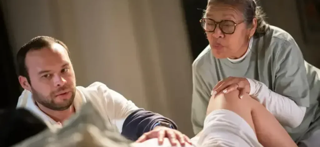 Padre y matrona asistiendo en un parto